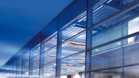 Moderne Bürogebäude Glasfassade bei Nacht.