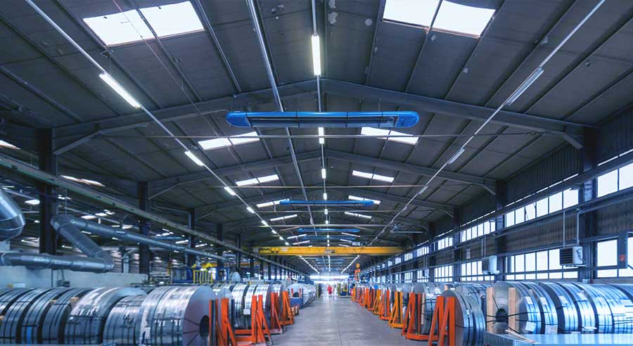Weitwinkelaufnahme einer Industriehalle von innen, die mit einer Infrarot-Hallenheizung beheizt wird.