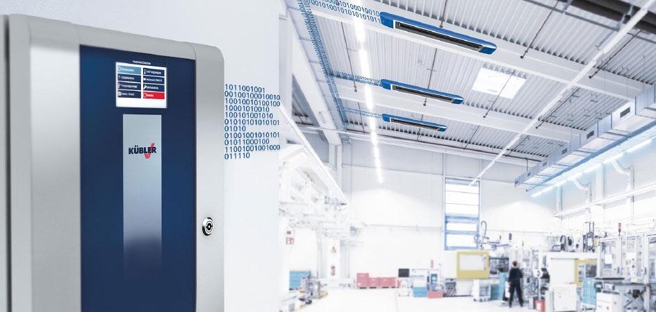 CELESTRA Steuerungssystem von KÜBLER Hallenheizungen, im Hintergrund eine Werkstatt mit blauem OPTIMA plus Hallenheizungssystem, das von der CELESTRA bedarfsgemäß gesteuert wird