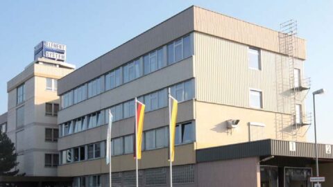 Bürogebäude mit deutschen Flaggen bei Tageslicht.