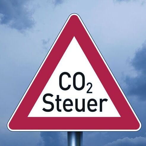 Straßenschild in Form eines Vorfahrt gewären Schildes, mit der Aufschrift CO2-Steuer.