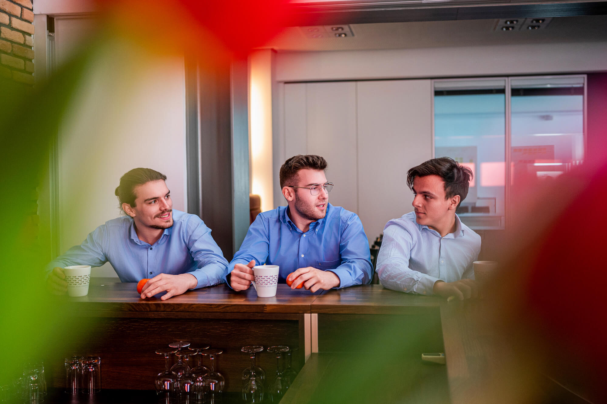 Drei männliche Auszubildende, die sich gemeinsam in der KÜBLER Lounge austauschen