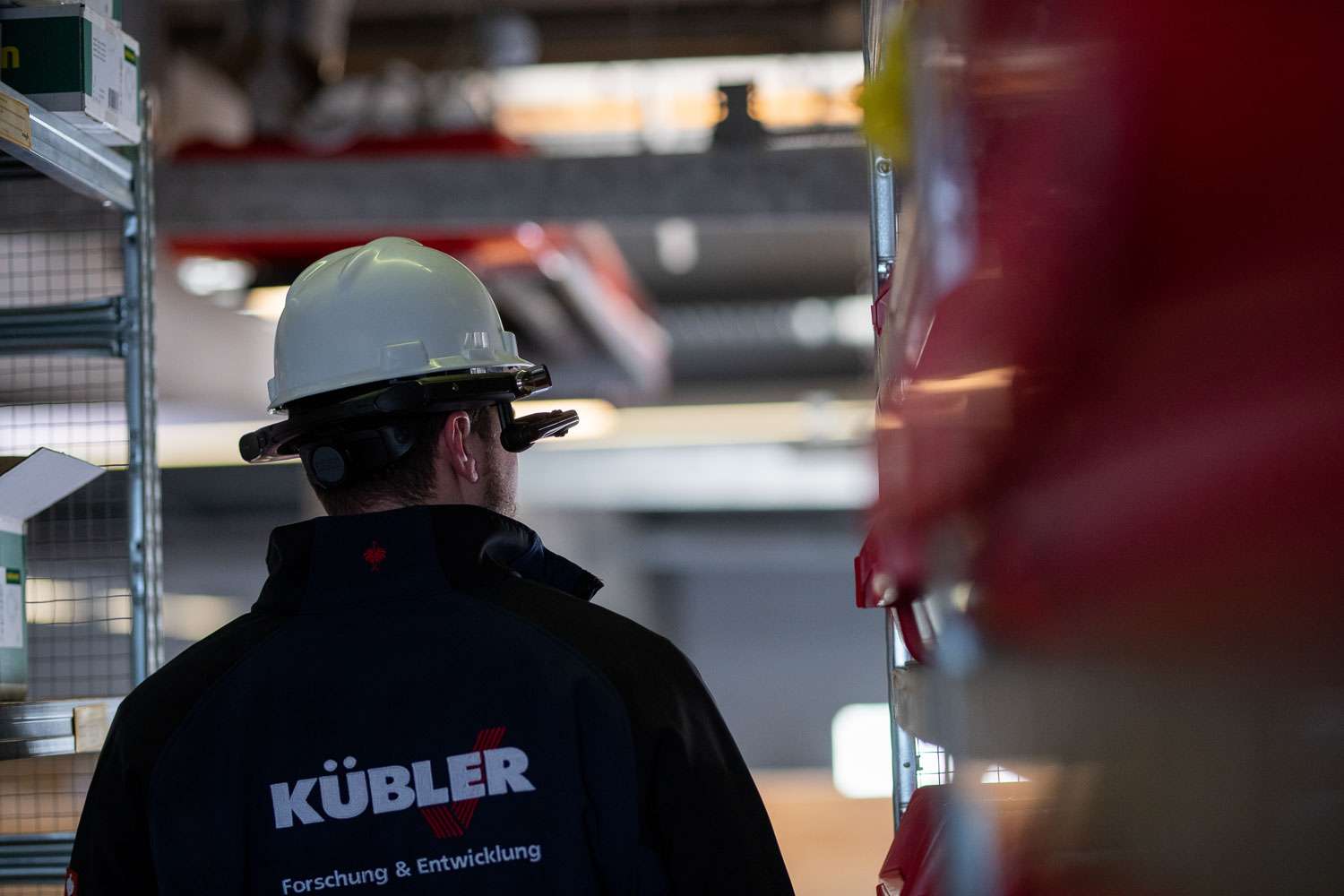 F&E Mitarbeiter von KÜBLER Hallenheizungen mit weißem Helm von hinten fotografiert