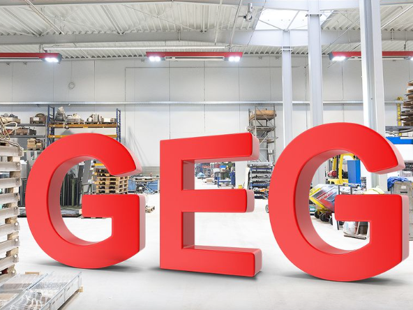 Rote Buchstaben GEG stehend in heller Industriehalle