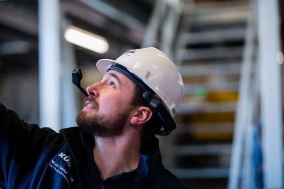 Ingenieur mit Helm schaut nach oben.