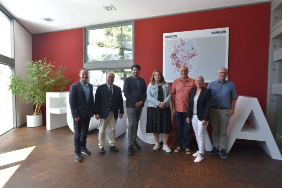 Teamfoto in modernem Bürogebäude.