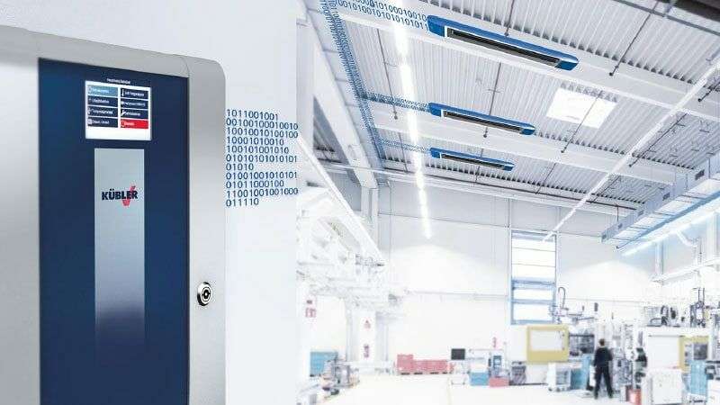 CELESTRA control system from KÜBLER hall heating systems, in the background a workshop with a blue OPTIMA plus hall heating system, which is controlled by the CELESTRA as required