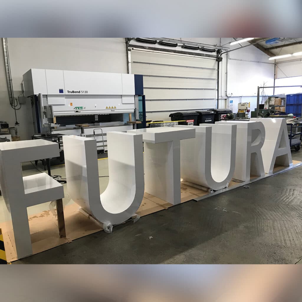 Große Buchstaben "FUTURA" in Werkstatthalle.