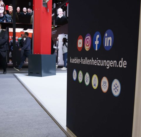 Messestand mit Social-Media-Symbolen und Unternehmenswebseite.