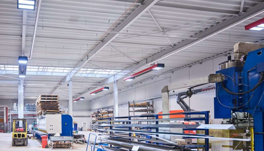 Moderne metalforarbejdningsfabrik med maskiner og lagerreoler