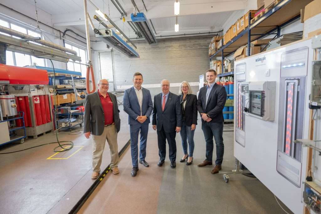People in an industrial hall with technical equipment