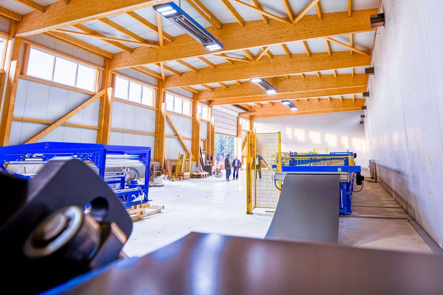 People in a bright factory hall with machines