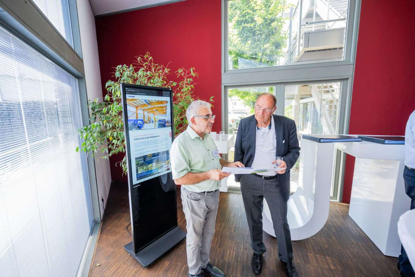 To herrer diskuterer ved en informationsstand