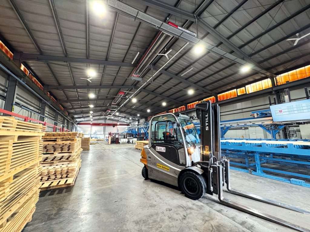A targonca fa raklapokat szállít a gyárcsarnokban