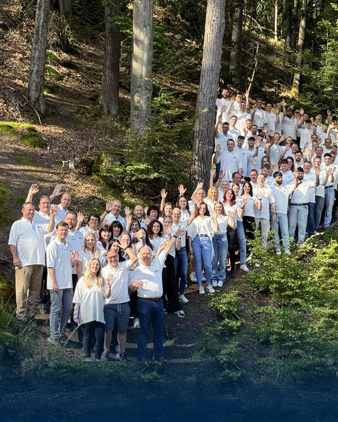 Gruppebilde av folk i skogen som vinker