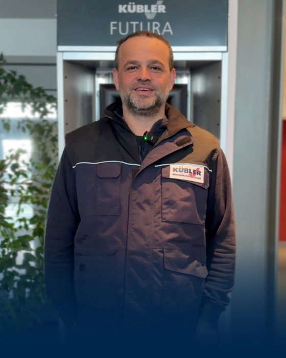 Mann in Arbeitsjacke vor Unternehmensschild