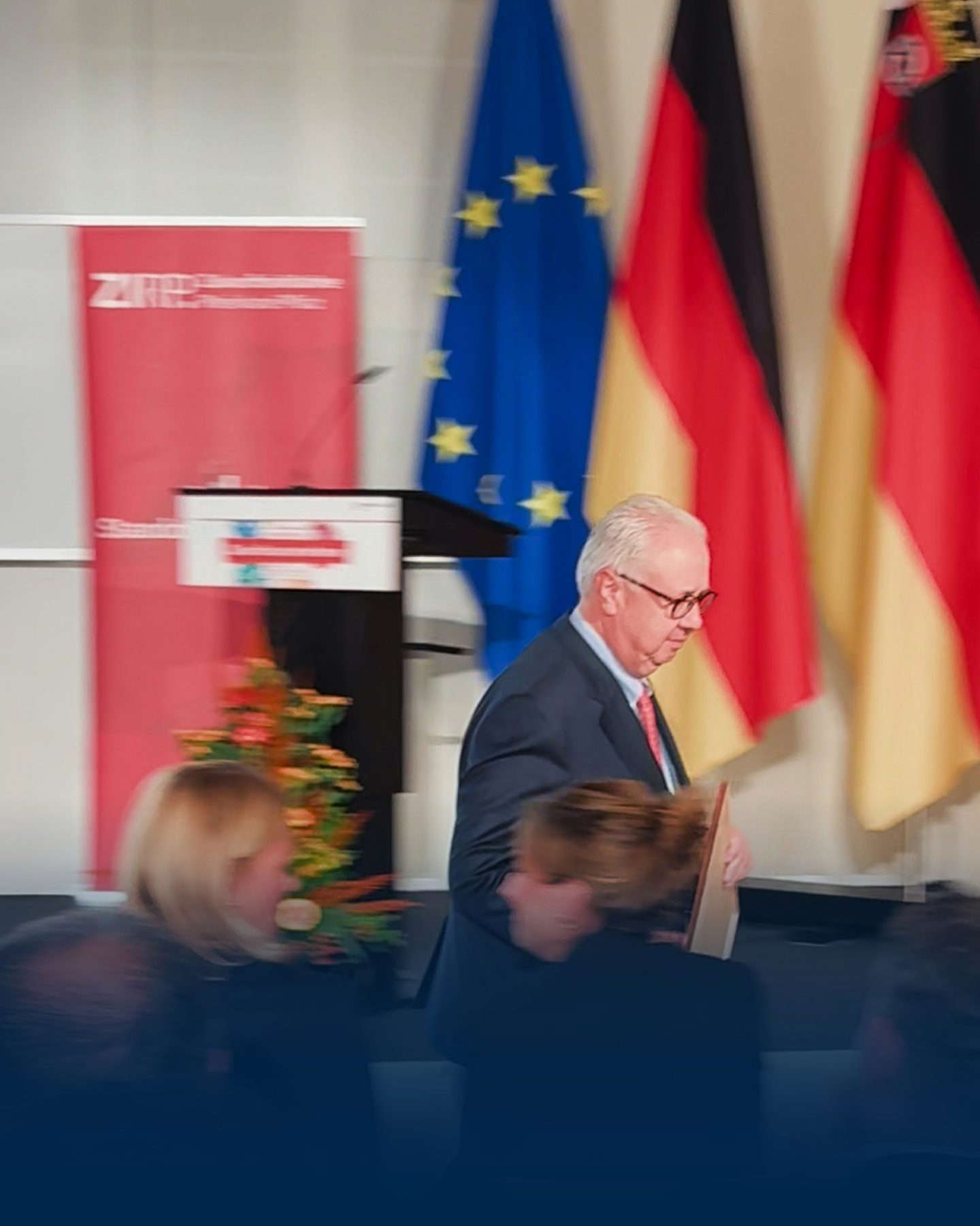 Mann bei Veranstaltung mit EU- und Deutschlandflaggen