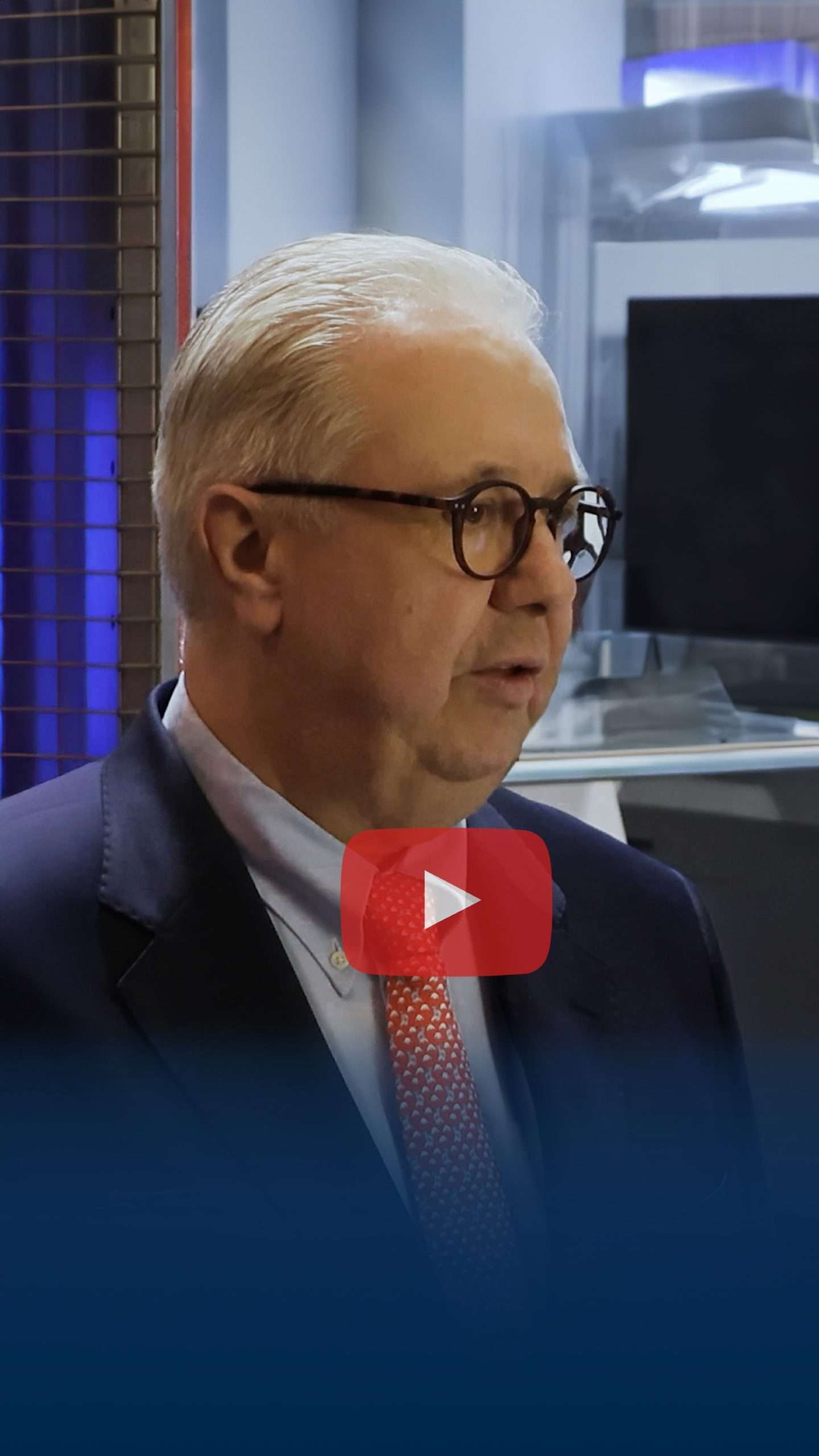 Man in a suit speaks in an interview.