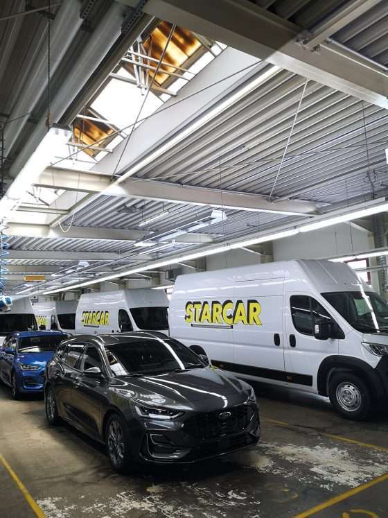 Fahrzeuge in einer beleuchteten Werkstatthalle geparkt