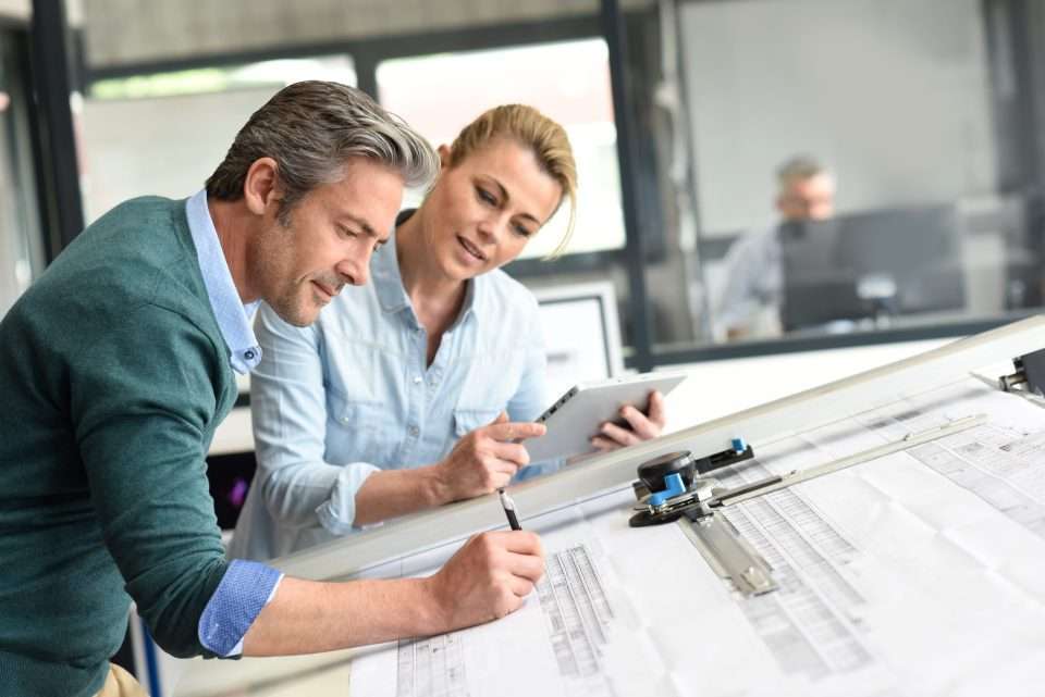 Arkitekter diskuterer byggeplaner i det moderne kontor