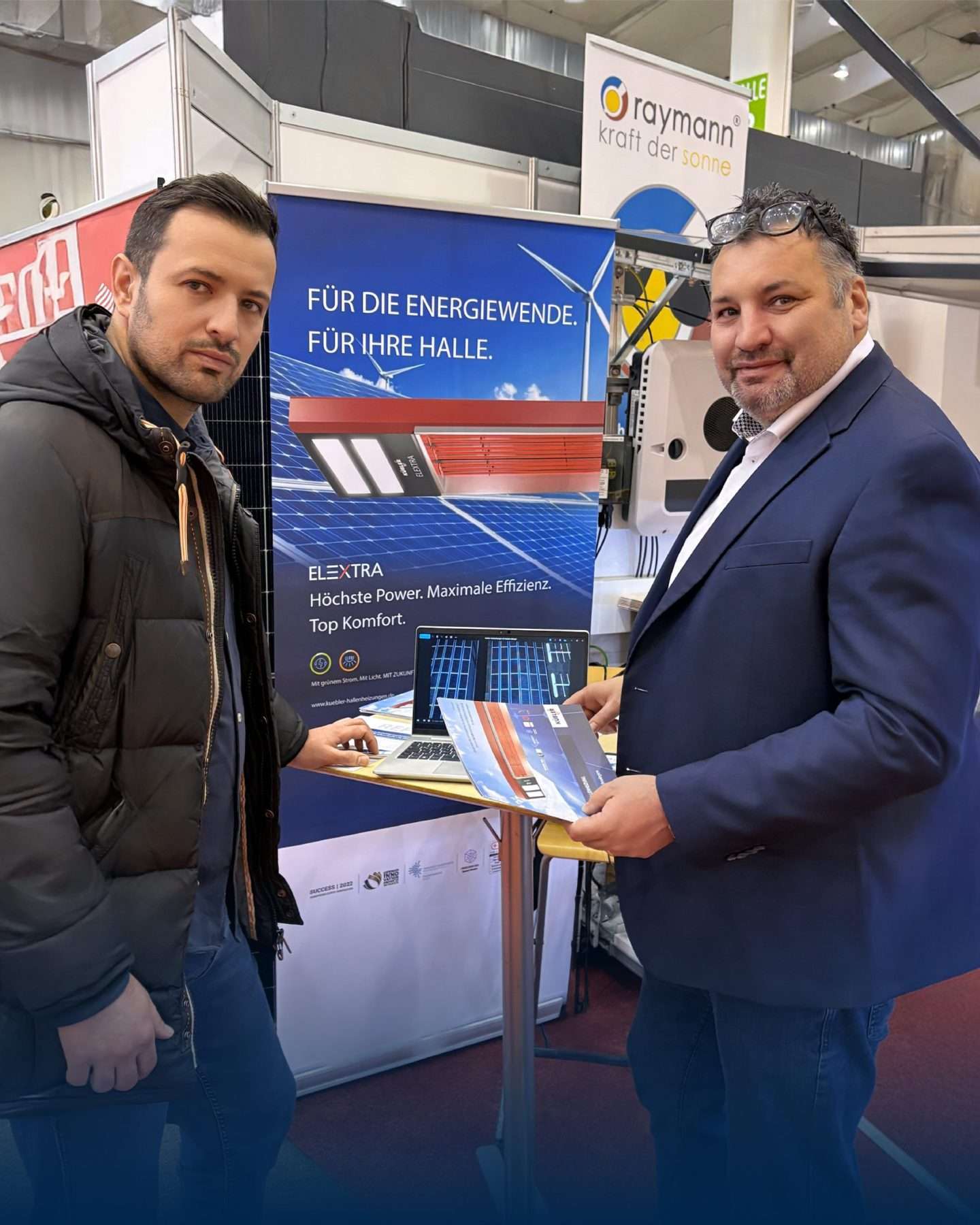 Zwei Männer auf Energiemesse mit Solartechnik-Stand.