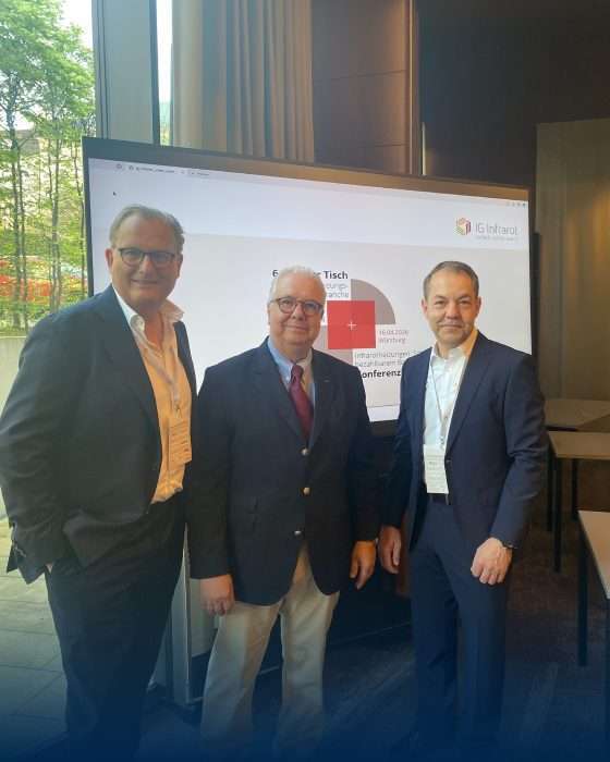 Drei Geschäftsleute vor Präsentationsbildschirm bei Konferenz